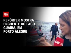 Repórter faz reportagem mostrando a enchente do Lago Guaíba em Porto Alegre